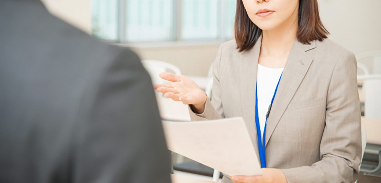 資料を見せながら説明するスタッフ
